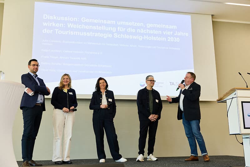 Mehrere Personen unterhalten sich auf der Bühne.