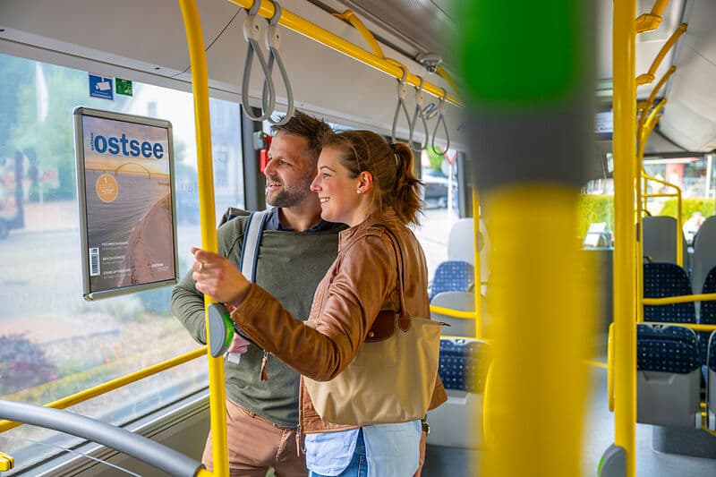 Vereister Hafen im Winter mit mehreren festgemachten Fischerbooten; vorn ein weißes Boot mit der Aufschrift „TIM6“, rechts zwei rote Boote, eines mit „NIE10“. Am Ufer liegt Schnee, der Himmel ist blau.